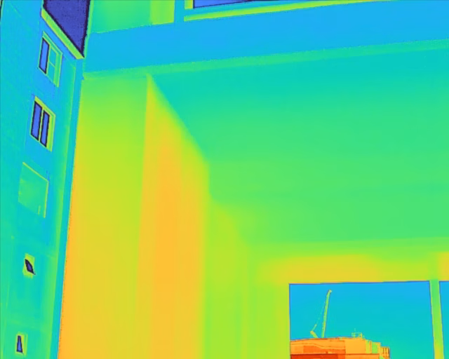 Color thermal survey of a building corner highlighting thermal bridging and heat transfer through structural elements.